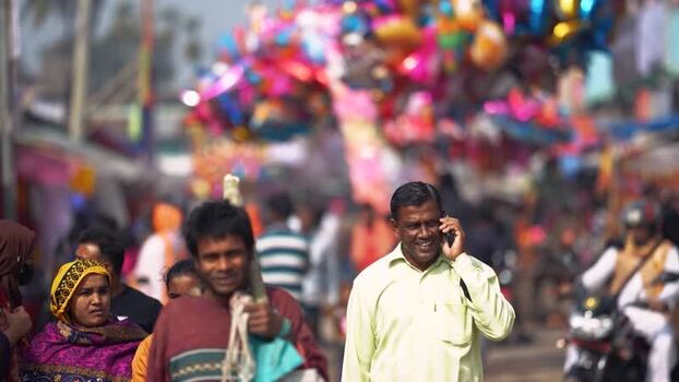 View of a man talking on a phone in a crowded street Bangladesh. View of a man talking on a phone in a crowded street Bangladesh.