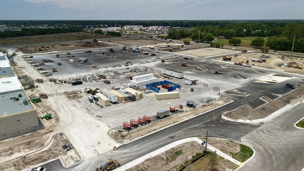 Aerial view of the construction site at Foundry Lane featuring heavy machinery shipping containers and paved areas in World Golf Village Florida United States.