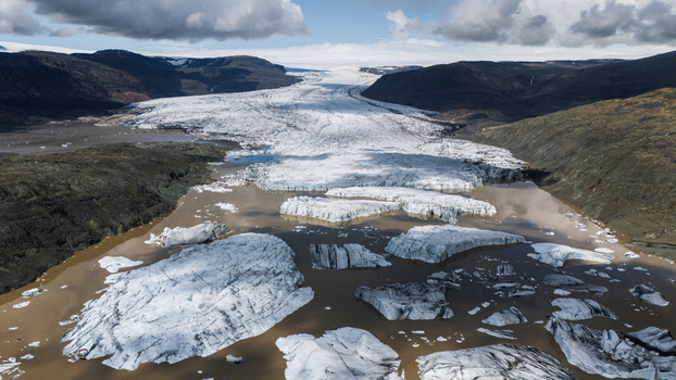 Aerial view of icebergs adrift in the glacial lagoon carved by time and weather against a backdrop of stark mountains Hoffellsjokull Iceland. Aerial view of icebergs adrift in the glacial lagoon carved by time and weather against a backdrop of stark mountains Hoffellsjokull Iceland.
