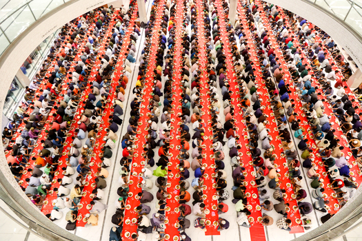 Dhaka Bangladesh 19 March 2025 View of a vast assembly of people their varied attire a vibrant mosaic against the striking crimson expanse of meticulously arranged dining tables. Dhaka Bangladesh 19 March 2025 View of a vast assembly of people their varied attire a vibrant mosaic against the striking crimson expanse of meticulously arranged dining tables.