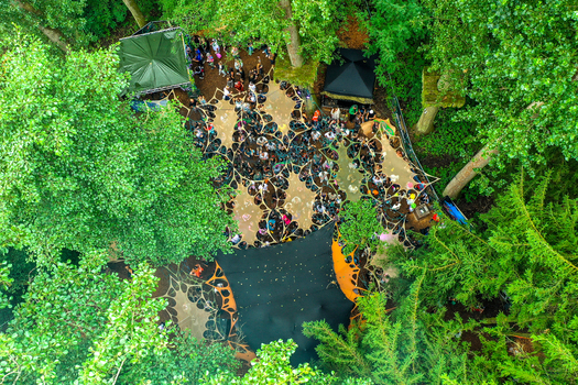 Herzogenaurach Germany 26 July 2025 Aerial view of the Open Beatz Festival with people gathered under canopies in a lush forest setting.