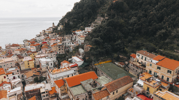 Aerial view of terracotta roofs cascading down the hillside towards the azure sea a picturesque blend of human construction and natural beauty Minori Campania Italy. Aerial view of terracotta roofs cascading down the hillside towards the azure sea a picturesque blend of human construction and natural beauty Minori Campania Italy.