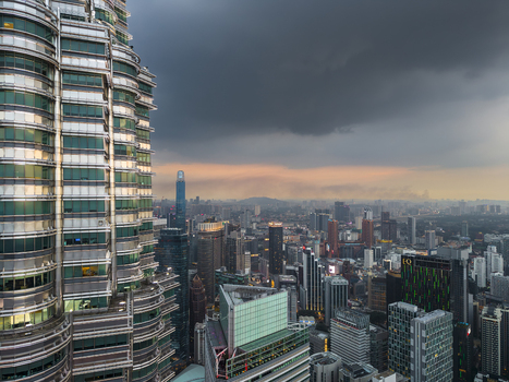 Kuala Lumpur Malaysia 11 March 2026 Aerial view of the Petronas Twin Towers overlooking the city skyline under a dramatic stormy sky at sunset.