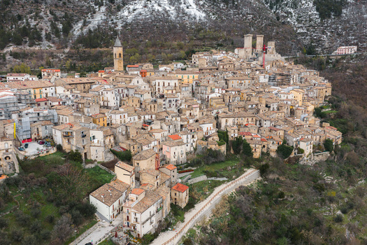 Aerial view of the medieval village of Pacentro with its historic stone buildings Caldora Castle and church tower nestled against snowy mountains in Pacentro Abruzzo Italy. Aerial view of the medieval village of Pacentro with its historic stone buildings Caldora Castle and church tower nestled against snowy mountains in Pacentro Abruzzo Italy.