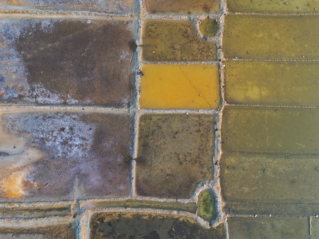 Aerial view of salt evaporation ponds with geometric grid patterns and varying water colors in Moheskhali Upazila Chittagong Division Bangladesh. Aerial view of salt evaporation ponds with geometric grid patterns and varying water colors in Moheskhali Upazila Chittagong Division Bangladesh.