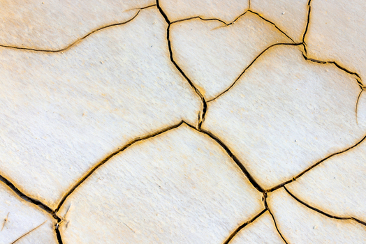 Aerial view of the cracked salt crust at Tuzbair showing intricate patterns of dry earth and fissures in the desert landscape of Mangystau District Mangystau Region Kazakhstan.