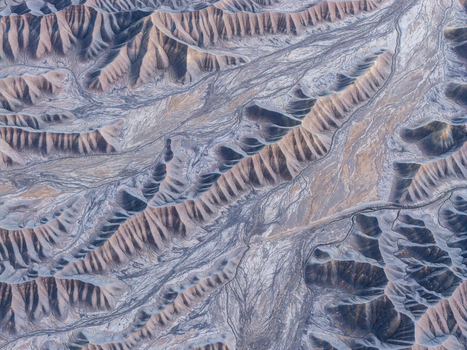 Aerial view of intricate eroded ridges and dry riverbeds in the desert landscape Hanksville Utah United States.