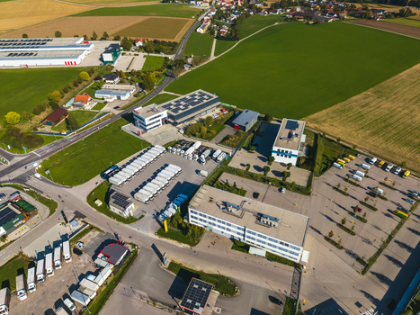 Aerial view of Logistikzentrum Allhaming featuring industrial buildings a large parking lot with trucks and surrounding green fields in Allhaming Oberosterreich Austria. Aerial view of Logistikzentrum Allhaming featuring industrial buildings a large parking lot with trucks and surrounding green fields in Allhaming Oberosterreich Austria.