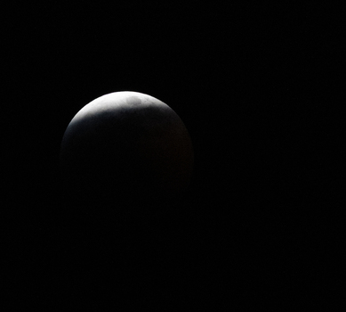 View of the moon during a partial lunar eclipse against the dark night sky in Canada. View of the moon during a partial lunar eclipse against the dark night sky in Canada.