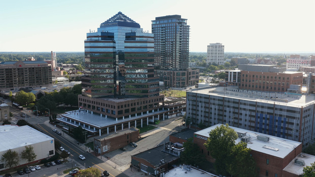 Aerial view of the modern glass faced skyscraper and surrounding urban buildings in downtown Durham North Carolina United States.