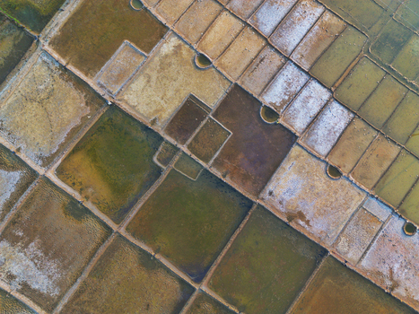 Aerial view of geometric salt evaporation ponds with textured surfaces and earthy tones in Moheskhali Upazila Chittagong Division Bangladesh. Aerial view of geometric salt evaporation ponds with textured surfaces and earthy tones in Moheskhali Upazila Chittagong Division Bangladesh.