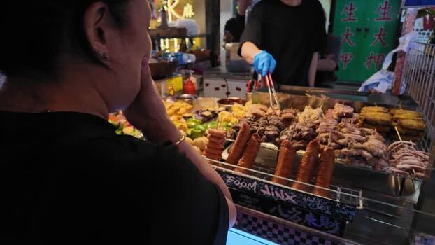 View of a street food vendor preparing skewers in Hong Kong.