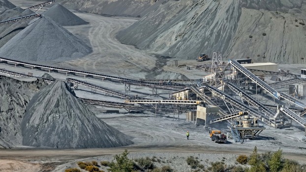 Aerial view of an industrial quarry site featuring large gravel piles a complex network of conveyor belts and heavy machinery in Golden Colorado United States.