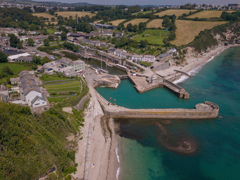 Aerial view of Charlestown Harbour featuring historic stone piers turquoise water and surrounding coastal village buildings in Charlestown Cornwall United Kingdom. Aerial view of Charlestown Harbour featuring historic stone piers turquoise water and surrounding coastal village buildings in Charlestown Cornwall United Kingdom.
