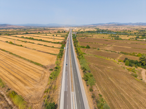 Aerial view of Highway Trakiya stretching through vast agricultural fields and golden farmland in Bulgaria. Aerial view of Highway Trakiya stretching through vast agricultural fields and golden farmland in Bulgaria.