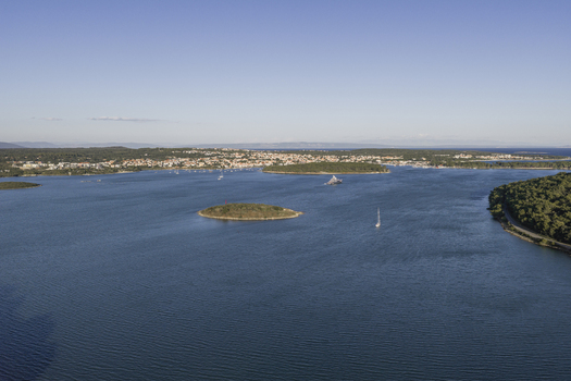 Aerial view of the coastal landscape of Premantura with small islands sailboats on the blue sea and the town in the background in Premantura Istria County Croatia. Aerial view of the coastal landscape of Premantura with small islands sailboats on the blue sea and the town in the background in Premantura Istria County Croatia.