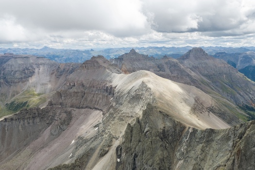 Aerial view of Mount Sneffels and the rugged peaks of the San Juan Mountains in the Rocky Mountains featuring dramatic rocky ridges and alpine terrain in Ouray County Colorado United States. Aerial view of Mount Sneffels and the rugged peaks of the San Juan Mountains in the Rocky Mountains featuring dramatic rocky ridges and alpine terrain in Ouray County Colorado United States.