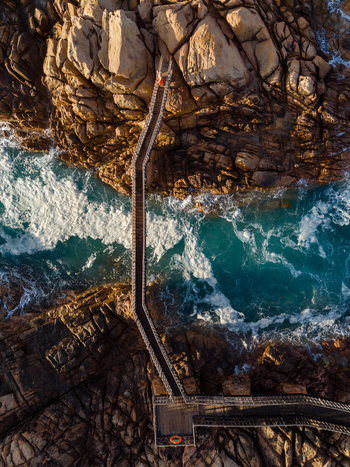 Aerial view of the Canal Rocks Bridge spanning rugged rock formations with turquoise water and crashing waves in Yallingup Western Australia Australia. Aerial view of the Canal Rocks Bridge spanning rugged rock formations with turquoise water and crashing waves in Yallingup Western Australia Australia.