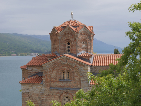 View of the historic Church of St. John at Kaneo with its brick and stone architecture and terracotta roof tiles overlooking Lake Ohrid in Ohrid Municipality of Ohrid North Macedonia. View of the historic Church of St. John at Kaneo with its brick and stone architecture and terracotta roof tiles overlooking Lake Ohrid in Ohrid Municipality of Ohrid North Macedonia.