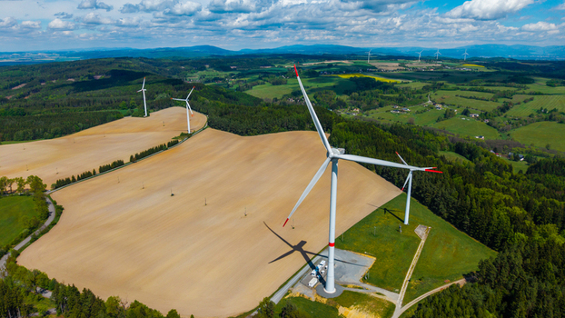 Aerial view of wind turbines standing in rolling agricultural fields and lush forests near Zipotin Gruna Pardubicky kraj Czechia. Aerial view of wind turbines standing in rolling agricultural fields and lush forests near Zipotin Gruna Pardubicky kraj Czechia.