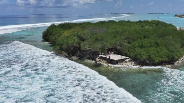 Aerial view of lush tropical island with breaking waves Maldives. Aerial view of lush tropical island with breaking waves Maldives.