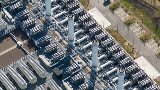 Aerial view of an industrial power plant facility featuring numerous cooling fans ventilation units and tall exhaust stacks in Dietzenbach Hessen Germany. Aerial view of an industrial power plant facility featuring numerous cooling fans ventilation units and tall exhaust stacks in Dietzenbach Hessen Germany.