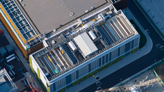 Aerial view of a modern industrial facility with complex rooftop mechanical equipment ventilation systems and green wall panels in Longcross England United Kingdom.