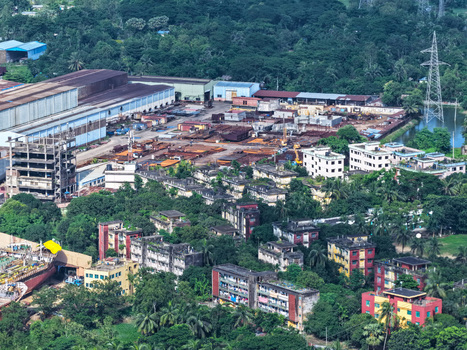 Aerial view of the industrial shipyard along the Karnaphuli River featuring warehouses metal structures and residential buildings in Chattogram Chattogram Division Bangladesh.