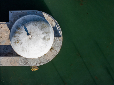 Aerial view of the historic Cascais Tide Gauge with its white dome and stone platform situated by the calm green waters of the Atlantic Ocean in Cascais Lisboa Portugal. Aerial view of the historic Cascais Tide Gauge with its white dome and stone platform situated by the calm green waters of the Atlantic Ocean in Cascais Lisboa Portugal.