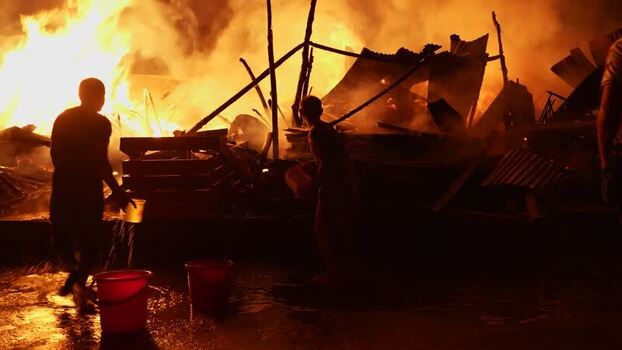 View of people fighting a massive fire at night Bangladesh. View of people fighting a massive fire at night Bangladesh.