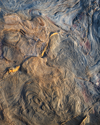 View of the intricate sandstone rock formations and swirling erosion patterns at Calafuria Toscana Italy.