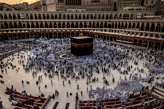 Aerial view of the Kaaba at the center of the Masjid al Haram courtyard surrounded by a large crowd of pilgrims in white ihram garments in Makkah Makkah Province Saudi Arabia. Aerial view of the Kaaba at the center of the Masjid al Haram courtyard surrounded by a large crowd of pilgrims in white ihram garments in Makkah Makkah Province Saudi Arabia.