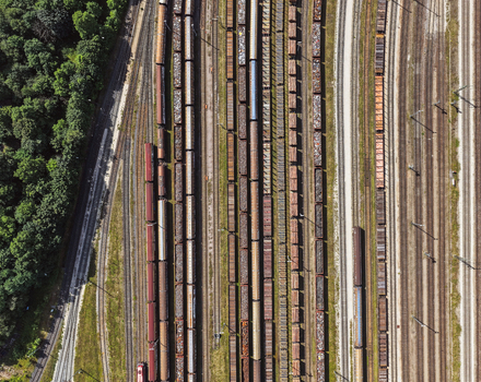 Aerial view of freight trains parked on multiple parallel railway tracks next to a dense forest in Saalfeld Thuringia Germany. Aerial view of freight trains parked on multiple parallel railway tracks next to a dense forest in Saalfeld Thuringia Germany.