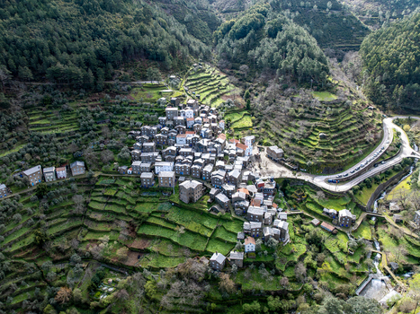 Aerial view of the clustered village nestled amid terraced hillsides a tapestry of earthy tones against the vibrant green Piódão Arganil Portugal. Aerial view of the clustered village nestled amid terraced hillsides a tapestry of earthy tones against the vibrant green Piódão Arganil Portugal.