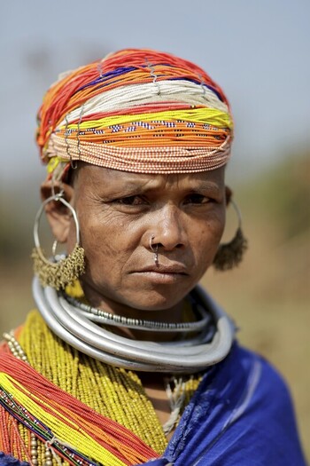 Odisha India 26 March 2026 View of a woman adorned with vibrant orange white and blue headwear contrasted with heavy silver necklaces and large earrings. Odisha India 26 March 2026 View of a woman adorned with vibrant orange white and blue headwear contrasted with heavy silver necklaces and large earrings.