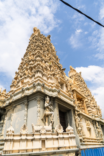 View of a Hindu temple featuring intricate carvings and statues against a blue sky in Galle Southern Province Sri Lanka.