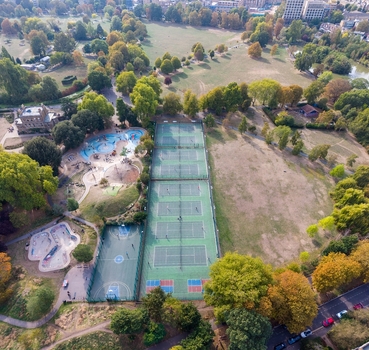 Aerial view of Clissold Park in Stoke Newington featuring tennis courts a skate park a playground and surrounding trees in London England United Kingdom.