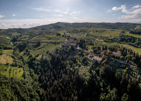 Aerial view of Montefioralle a historic hilltop village surrounded by lush vineyards olive groves and dense forests under a bright sky in Montefioralle Tuscany Italy. Aerial view of Montefioralle a historic hilltop village surrounded by lush vineyards olive groves and dense forests under a bright sky in Montefioralle Tuscany Italy.