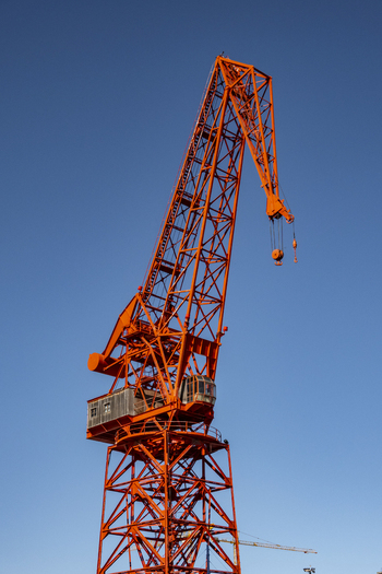 View of the historic red Carola crane standing tall against a clear blue sky at the maritime museum docks in Greater Bilbao Basque Country Spain. View of the historic red Carola crane standing tall against a clear blue sky at the maritime museum docks in Greater Bilbao Basque Country Spain.
