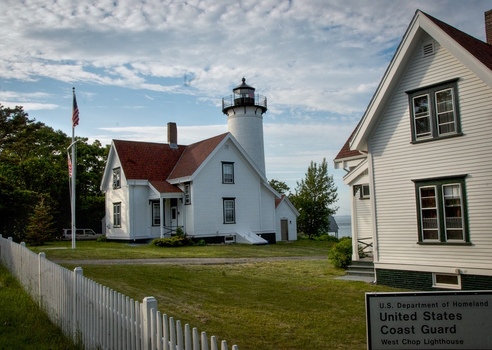 Edgartown United States 14 May 2026 View of West Chop Lighthouse and its white keeper s house with red roofs under a cloudy sky.