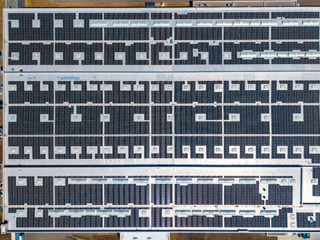 Aerial view of the Glas Trosch Alsace SAS industrial facility roof covered with extensive solar panel arrays in Hombourg Grand Est France.