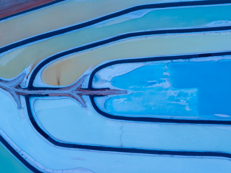Aerial view of colorful evaporation ponds with vibrant blue and yellow mineral rich water separated by dark embankments in Colorado United States. Aerial view of colorful evaporation ponds with vibrant blue and yellow mineral rich water separated by dark embankments in Colorado United States.