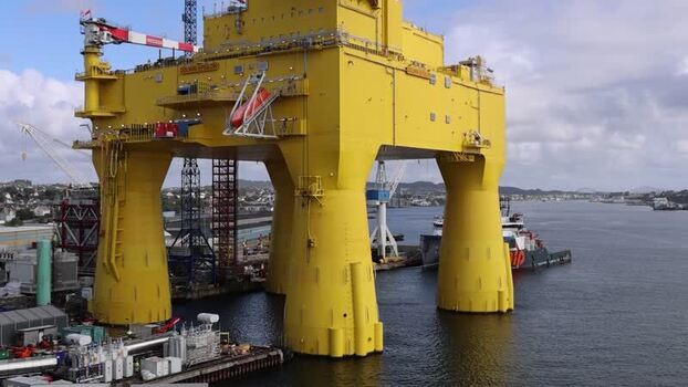Aerial view of a massive yellow offshore platform in Norway.