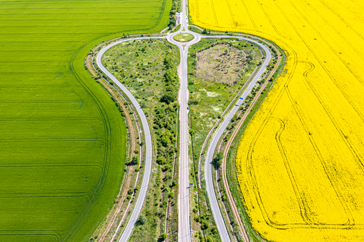 Aerial view of a heart shaped road junction separating vibrant green agricultural fields and bright yellow rapeseed crops Ploiesti Prahova Romania. Aerial view of a heart shaped road junction separating vibrant green agricultural fields and bright yellow rapeseed crops Ploiesti Prahova Romania.