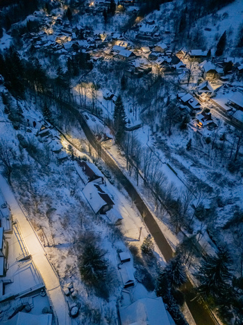 Aerial view of the snow covered village of Spania Dolina with glowing lights and winter landscape in Spania Dolina Banska Bystrica Region Slovakia. Aerial view of the snow covered village of Spania Dolina with glowing lights and winter landscape in Spania Dolina Banska Bystrica Region Slovakia.