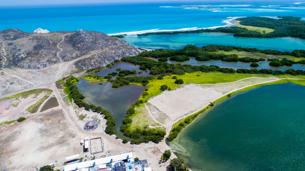 Aerial view of Los Roques archipelago featuring turquoise waters lush mangroves and sandy coastal terrain under a clear blue sky in Los Roques Dependencias Federales Venezuela. Aerial view of Los Roques archipelago featuring turquoise waters lush mangroves and sandy coastal terrain under a clear blue sky in Los Roques Dependencias Federales Venezuela.