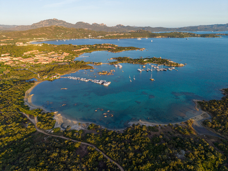 Aerial view of the Gulf of Marinella with turquoise waters moored yachts and lush coastal vegetation in Marinella Sardegna Italy. Aerial view of the Gulf of Marinella with turquoise waters moored yachts and lush coastal vegetation in Marinella Sardegna Italy.