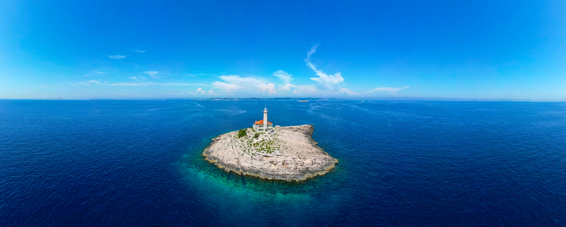 Aerial view of Blitvenica Lighthouse on a small rocky islet surrounded by the deep blue Adriatic Sea under a clear summer sky Zirje Sibensko kninska zupa Croatia. Aerial view of Blitvenica Lighthouse on a small rocky islet surrounded by the deep blue Adriatic Sea under a clear summer sky Zirje Sibensko kninska zupa Croatia.