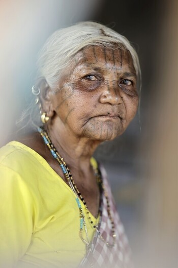 Odisha India 26 March 2026 View of an elderly woman with striking facial tattoos gold earrings and a vibrant yellow blouse her gaze holding stories of a life etched in time. Odisha India 26 March 2026 View of an elderly woman with striking facial tattoos gold earrings and a vibrant yellow blouse her gaze holding stories of a life etched in time.