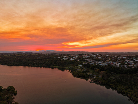 Aerial view of the coastal town of Kingscliff at sunset with vibrant orange clouds reflecting over the river and surrounding landscape in Kingscliff New South Wales Australia. Aerial view of the coastal town of Kingscliff at sunset with vibrant orange clouds reflecting over the river and surrounding landscape in Kingscliff New South Wales Australia.